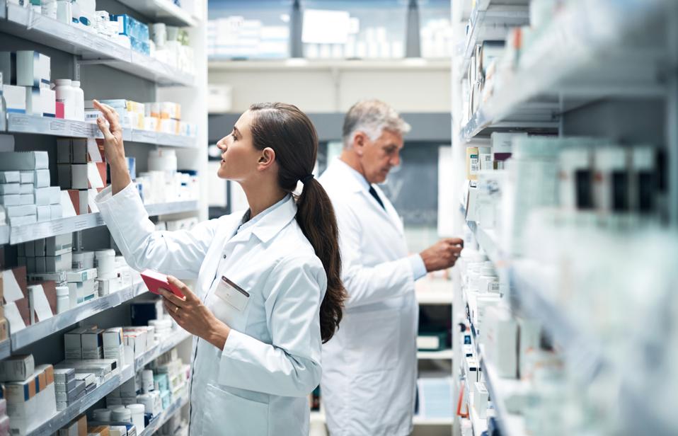 Professional pharmacists working with organized medication shelves at AV Chemist - specialized personal injury pharmacy services in New York and New Jersey